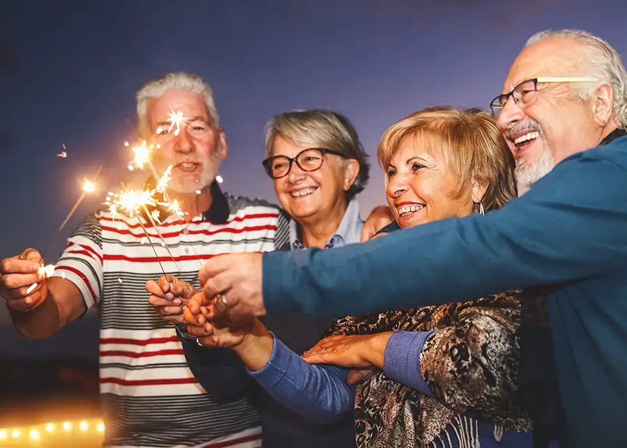Group of elderly friends with sparklers celebrating - Senior living community - St. Charles, MO